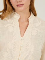 Blusa con bordado a tono confeccionada en tejido de algodón con textura ligera, que aporta un aire natural y refinado.