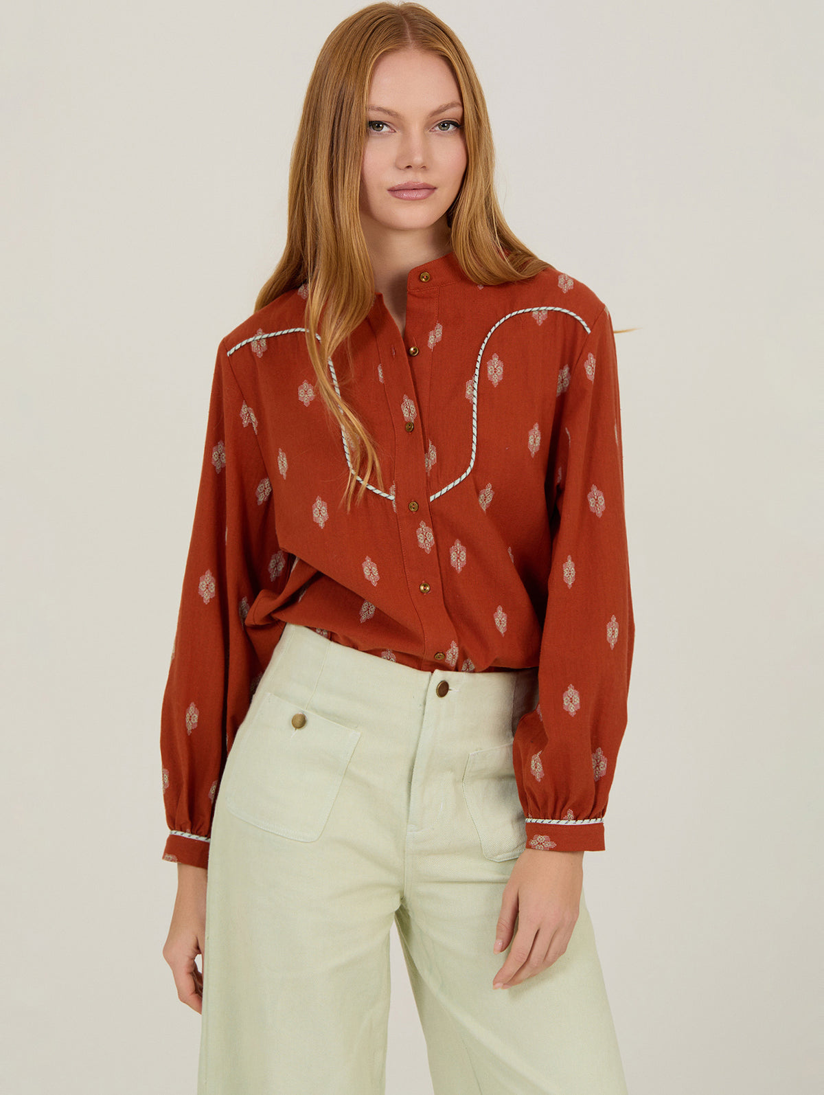 Mujer con blusa estampada anaranjada con detalle de vivo