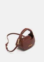 Compacto y lleno de estilo, este mini bolso de mano presenta un diseño estructurado con asa superior esférica y un elegante aplique.