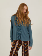 Camisa con volante frontal de manga larga confeccionada en un suave tejido fluido en color azul grisáceo.