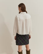 Camisa corta blanca oversize con dobladillo y mangas con bordado de efecto ondulado.