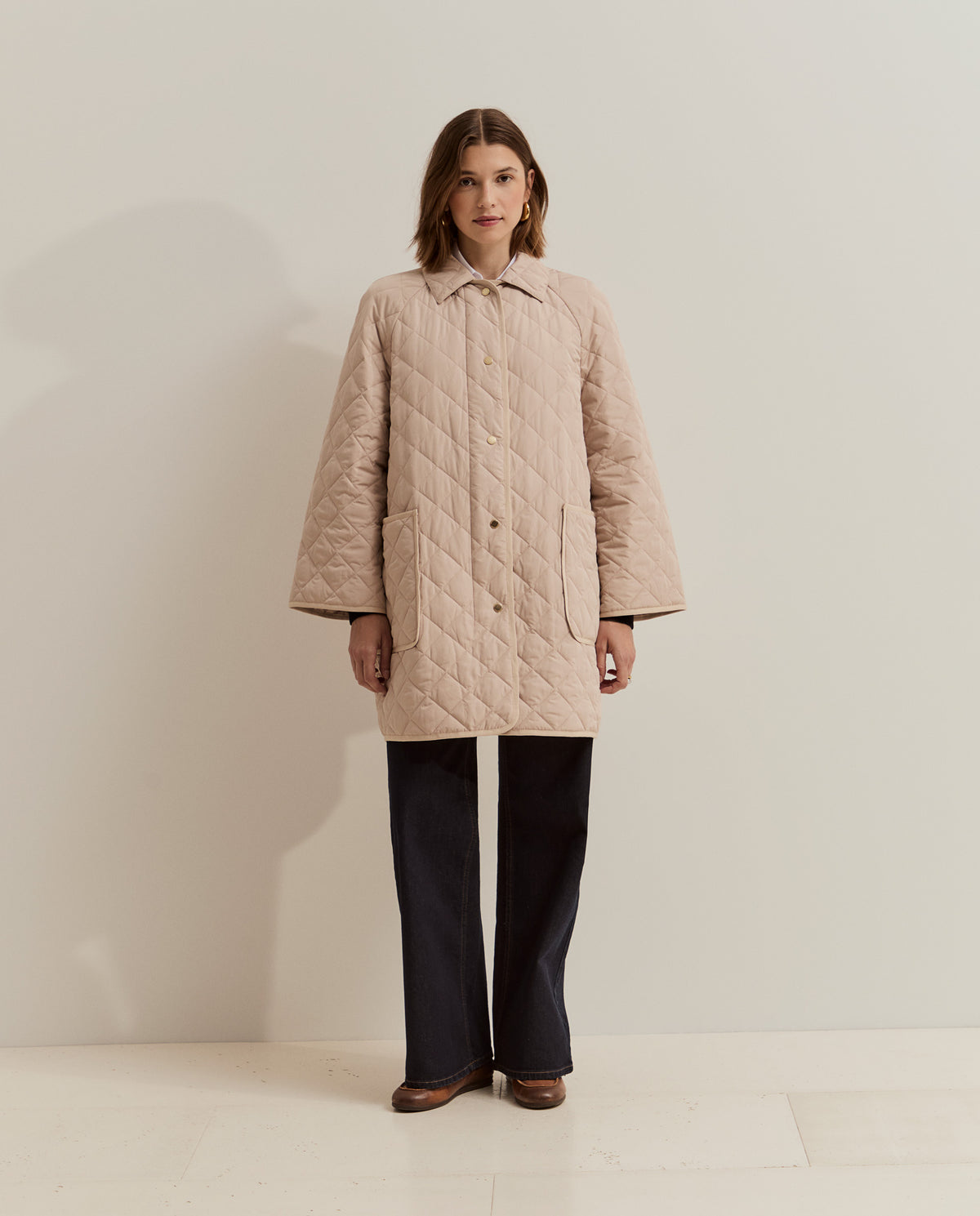 Esta chaqueta acolchada larga de mujer combina un diseño de rombos con un corte holgado, perfecto para llevar sobre tus prendas de punto.