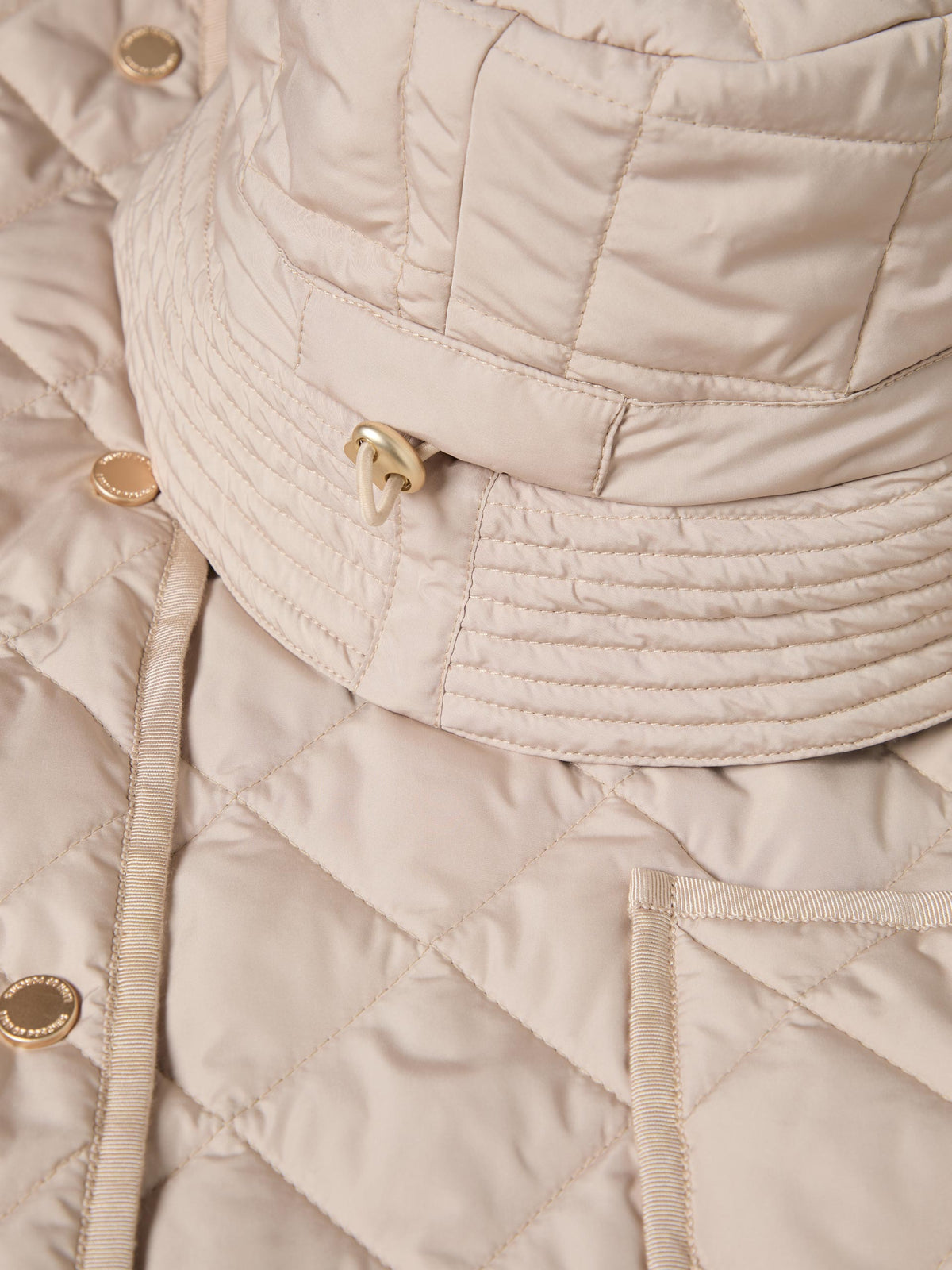 Esta chaqueta acolchada larga de mujer combina un diseño de rombos con un corte holgado, perfecto para llevar sobre tus prendas de punto.