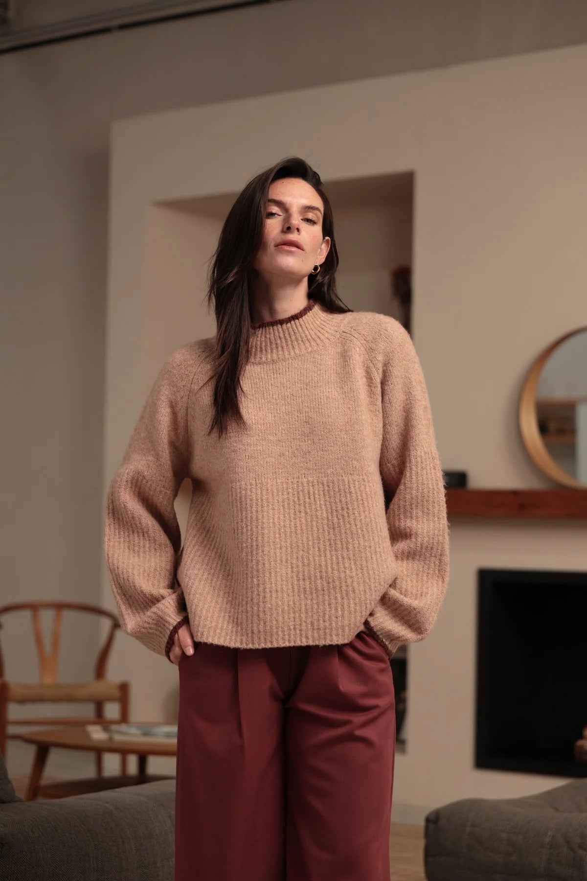 Modelo con jersey rosa empolvado de punto texturizado y ribetes burdeos en cuello y puños