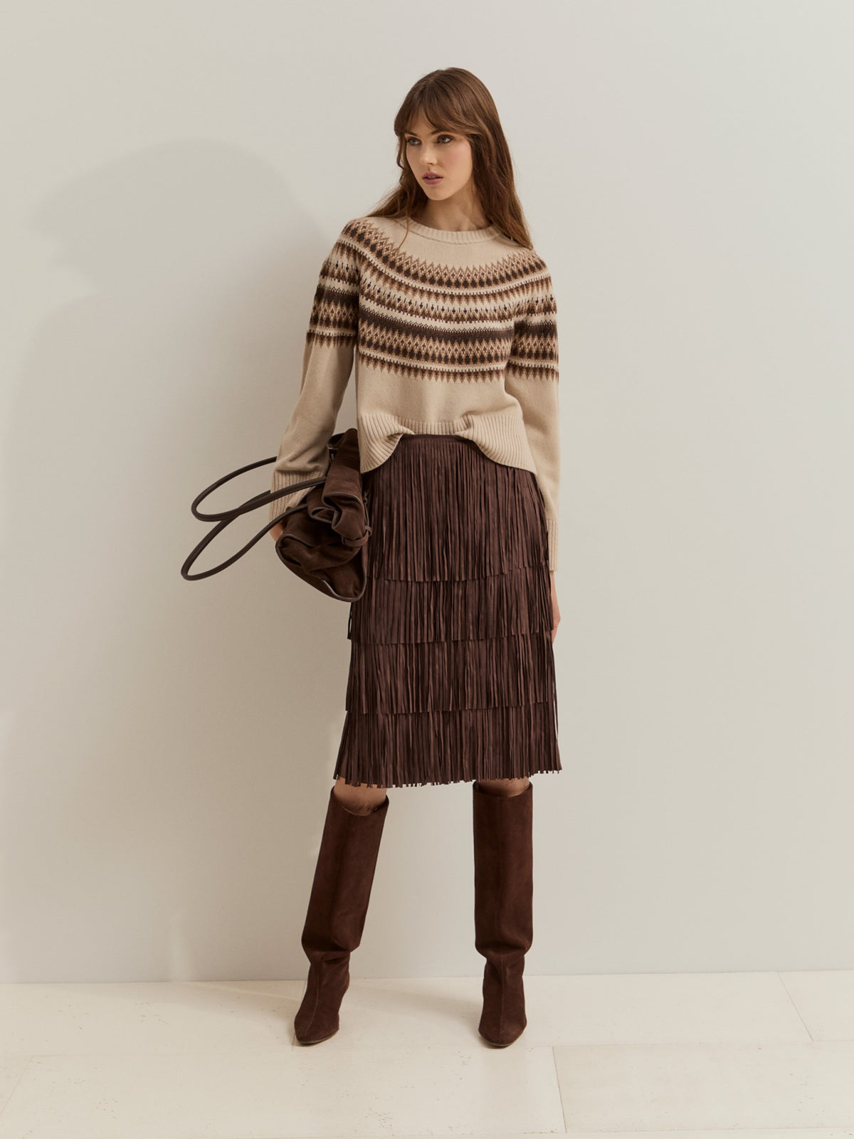 Jersey de punto con 80% lana y estampado geométrico nórdico. Diseño de manga larga, cuello redondo y acabados acanalados, ideal para el invierno.
