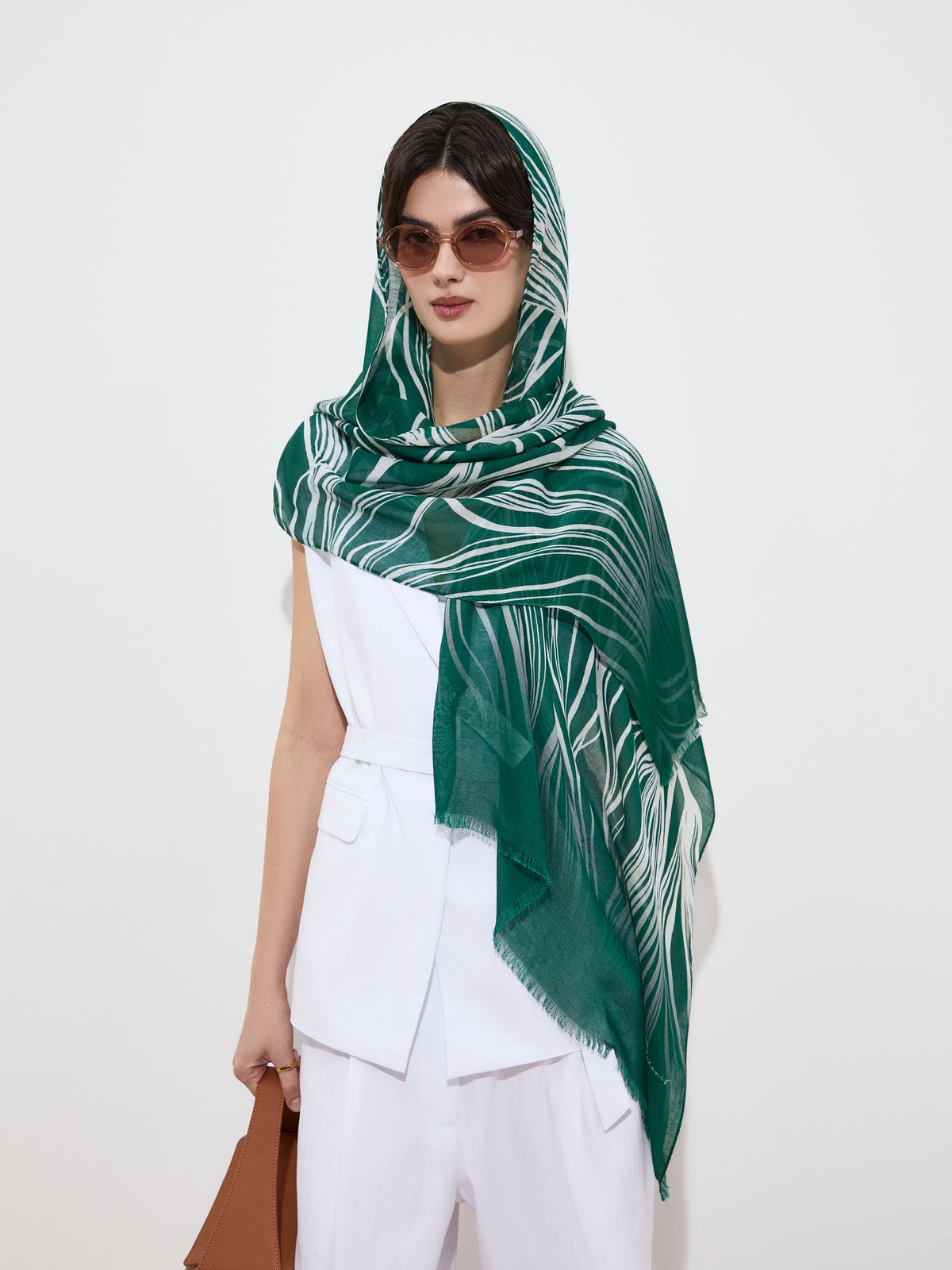 Mujer con pañuelo largo verde estampado y gafas de sol