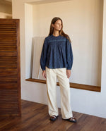 Modelo con camisa azul estampada, canesú bordado con pliegues y mangas largas con volumen
