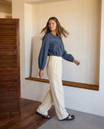 Modelo con camisa azul estampada, canesú bordado con pliegues y mangas largas con volumen