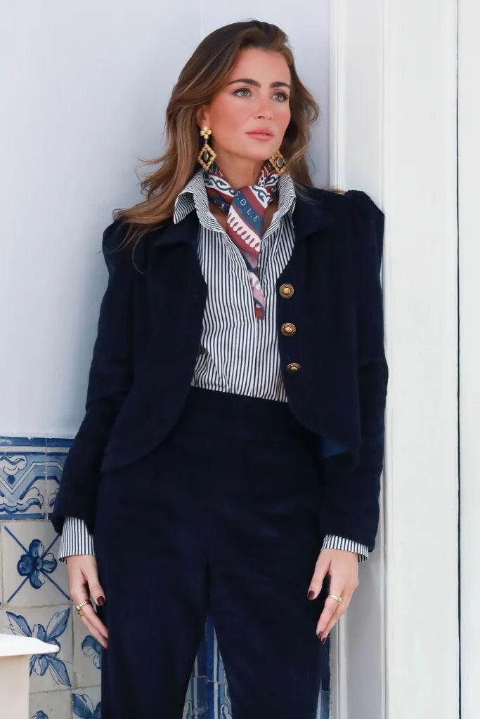 Modelo con chaqueta corta de pana azul y botones dorados, combinada con pantalones Aurora a juego