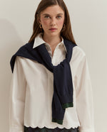 Camisa corta blanca oversize con dobladillo y mangas con bordado de efecto ondulado.