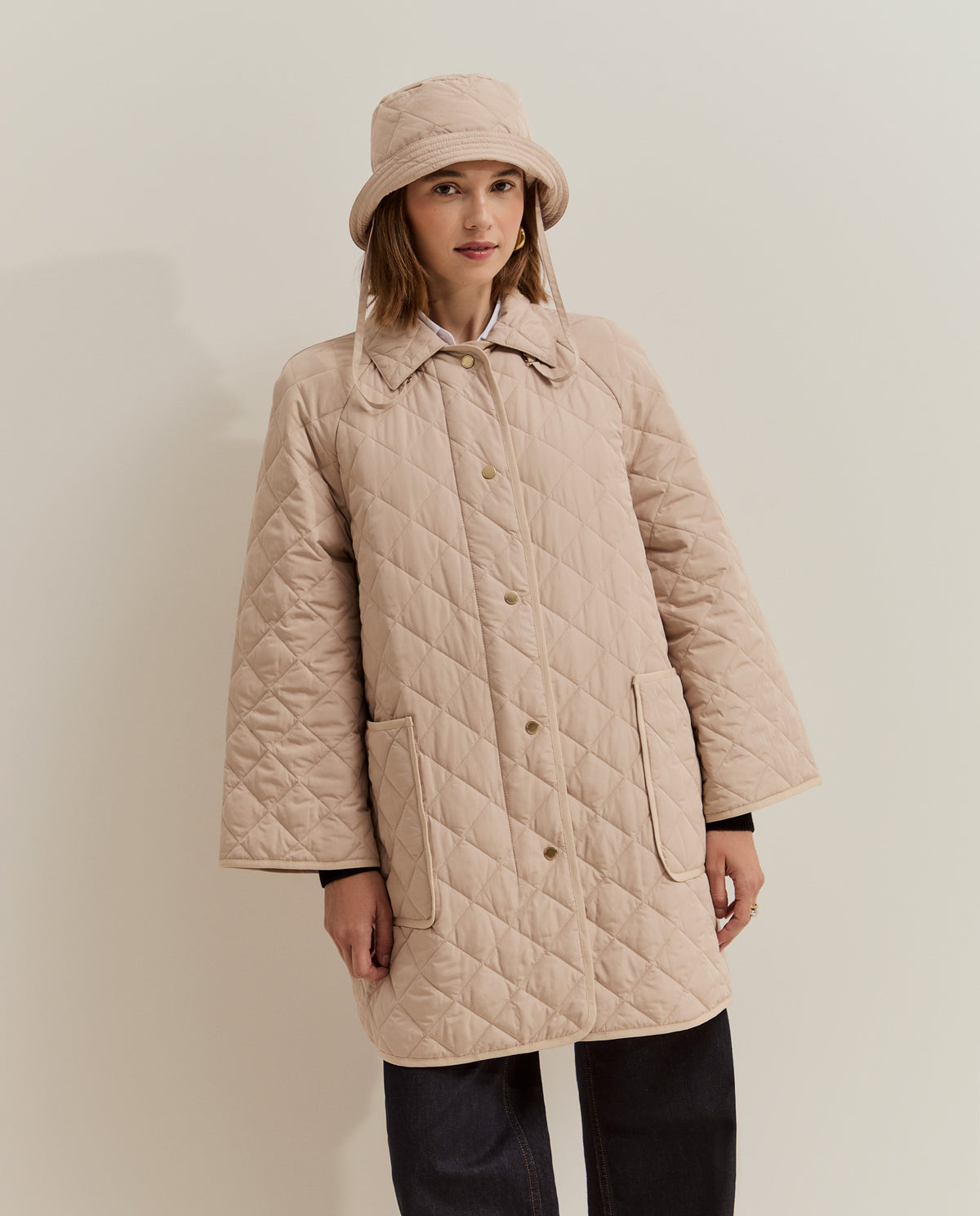 Esta chaqueta acolchada larga de mujer combina un diseño de rombos con un corte holgado, perfecto para llevar sobre tus prendas de punto. 