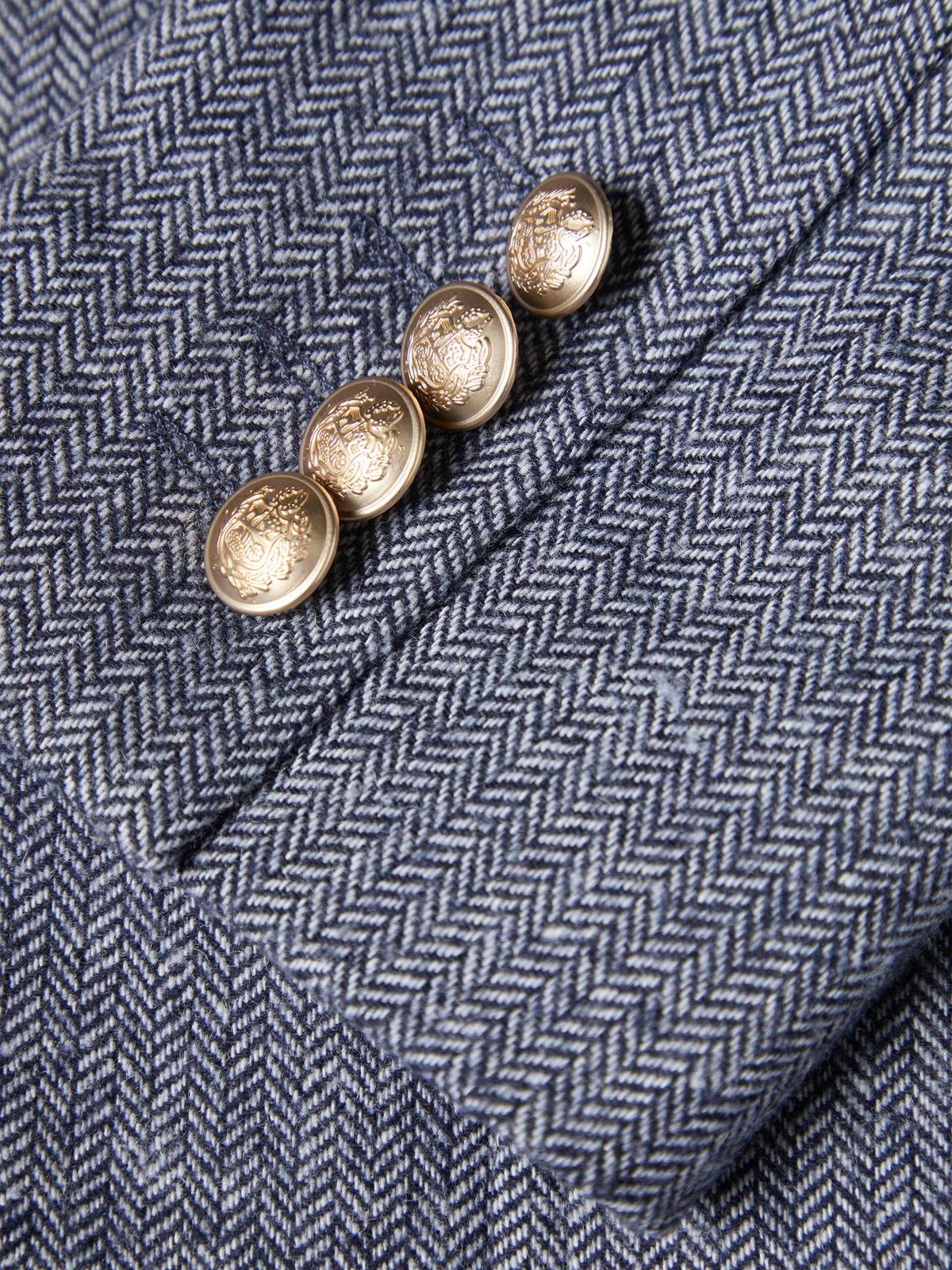 Modelo con blazer de espiga y botones metálicos combinada con jersey rojo y vaqueros