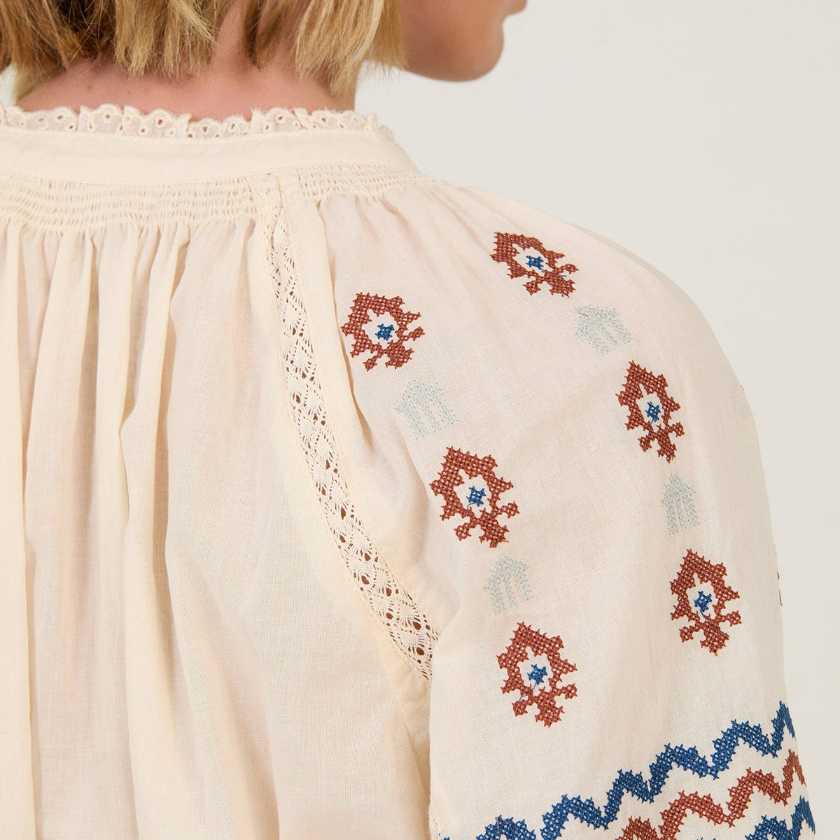 Detalle de bordados en tonos marrón y azul grisáceo