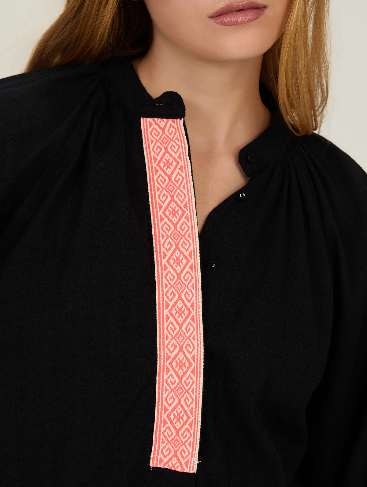 Detalle de la fornitura flúor en camisa negra de manga larga