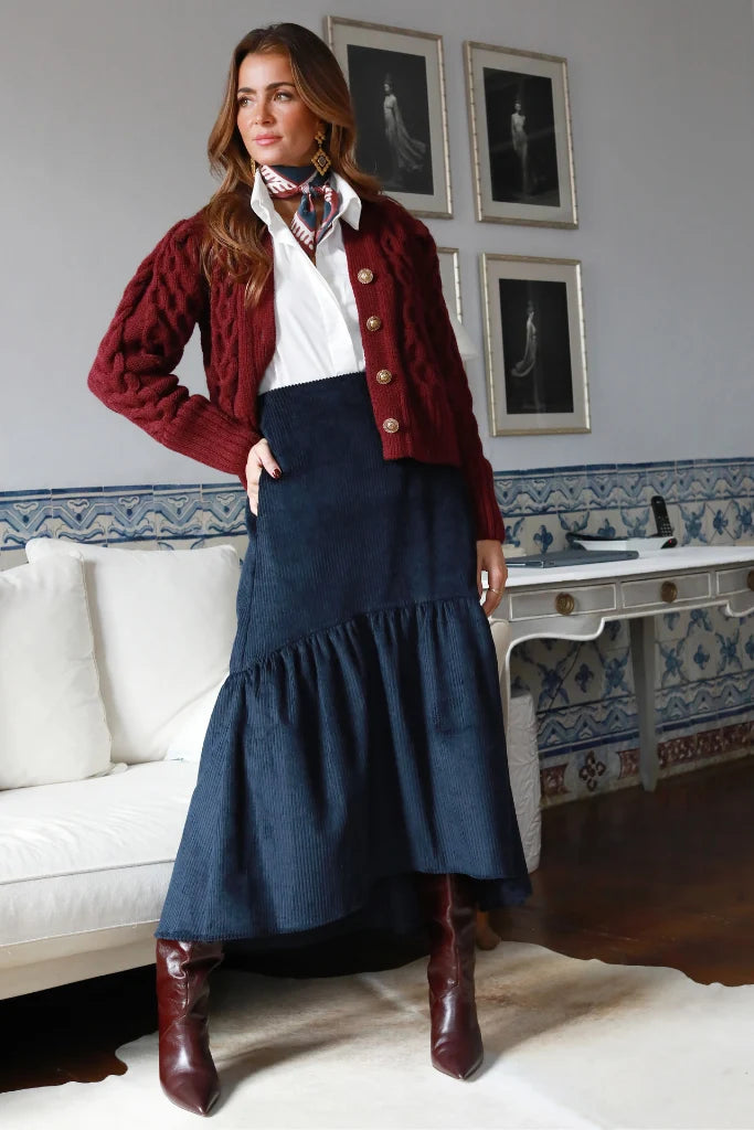 Falda midi de pana azul marino de corte evasé, combinada con camisa blanca y chaqueta azul marino