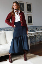 Falda midi de pana azul marino de corte evasé, combinada con camisa blanca y chaqueta azul marino