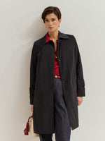 Gabardina midi con cuello de solapa y cierre frontal con botones ocultos.