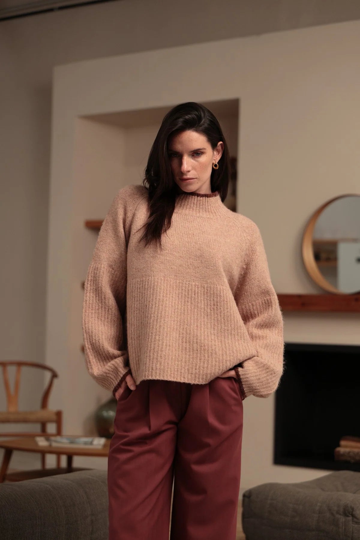 Modelo con jersey rosa empolvado de punto texturizado y ribetes burdeos en cuello y puños