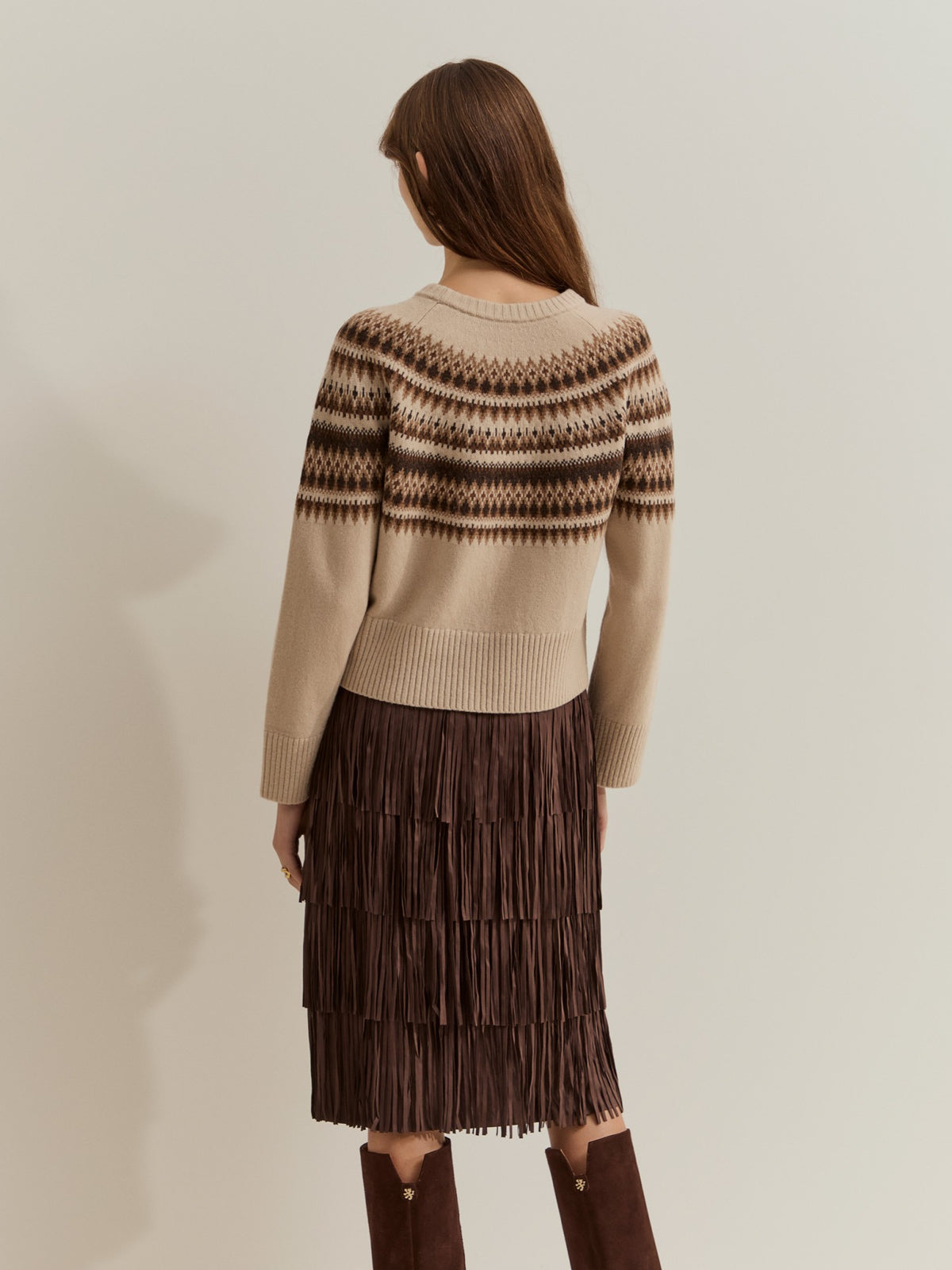 Jersey de punto con 80% lana y estampado geométrico nórdico. Diseño de manga larga, cuello redondo y acabados acanalados, ideal para el invierno.