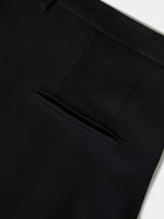 Pantalón negro de pierna ancha confeccionado en 100% viscosa, con pliegues delanteros, bolsillos laterales y traseros y cierre con gancho y cremallera.