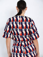 Blusa Satinada con Estampado Gráfico y Detalle Metálico